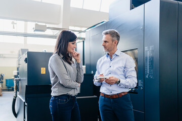 Businessman and businesswoman having a work meeting in a factory