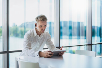 Businessman doing a call with a headset, using digital tablet