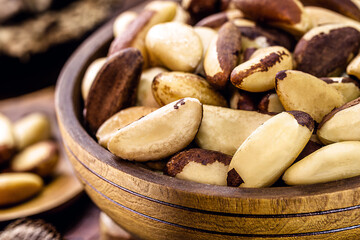 bowl with peeled Brazil nuts on a rustic table. healthy cooking ingredient