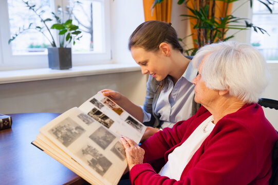 Grandmother and granddaughter looking photo album at home