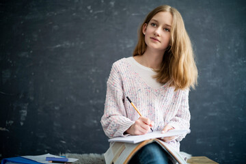 Girl learning at home, writing in exercise book