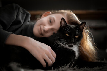 Girl cuddling with black cat