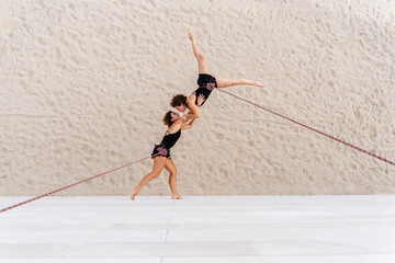 Aerial dancers dancing while hanging against wall