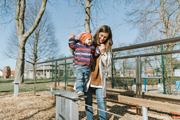 Happy mother with little daughter on a playground