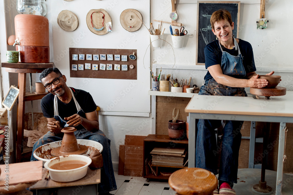 Wall mural smiling male and female potters working in workshop