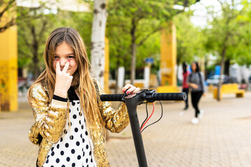 Portrait of smiling girl with scooter wearing golden sequin jacket