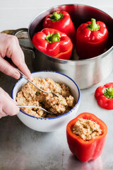 Hands of man preparing stuffed bell peppers with spelt
