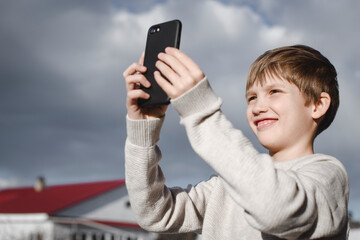 Portrait of happy boy taking selfie with smartphone