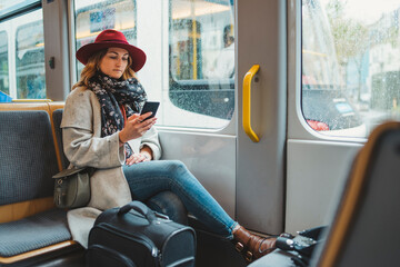 Young woman using cell phone in a tram