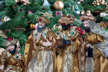 The Three Wise Men with the Christmas tree in the background.