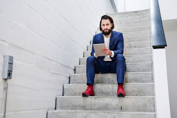 Businessman using tablet on stairs