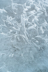 Background frozen water with fancy patterns. Ice texture. Cracks and bubbles inside frozen water.