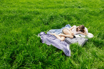 Relaxed woman lying on a meadow reading a book