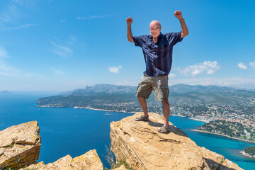 Senior man standing on cliff - obrazy, fototapety, plakaty