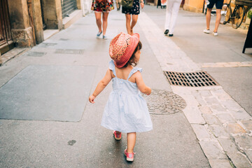 France, Aix-en-Provence, toddler girl walking down the streets of the city center - obrazy, fototapety, plakaty