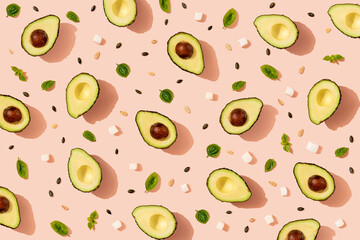 Pattern of halved avocados,pumpkin seeds, basil and pieces of cheese