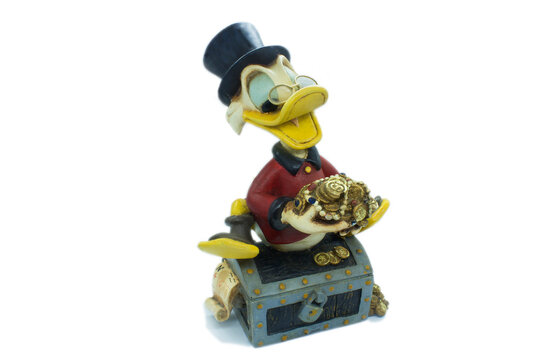 Studio image of Scrooge mcduck with a money chest on  a white isolated background.