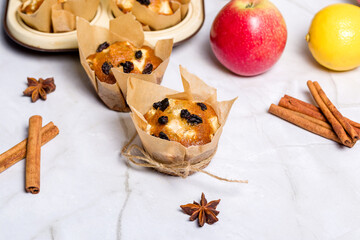 Homemade muffin with apples, raisins and cinnamon sticks. On a light background