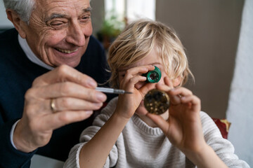 Watchmaker and his grandson examining watch together