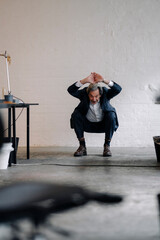 Senior businessman doing gymnastics in office