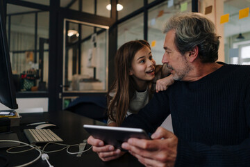 Casual senior buisinessman and girl with tablet in office