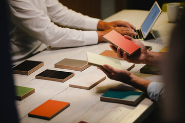 Hands of architects choosing colour samples in office