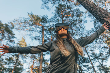 Young woman using VR goggles in nature