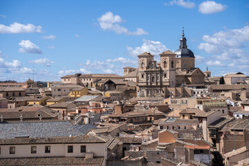 Obraz premium Jesuit Church of San Ildefonso seen between the rooftops of the city of Toledo, Spain, on a sunny day with few clouds