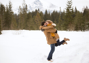 Happy young couple in snow-covered winter landscape