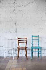 Empty chairs against white brick wall