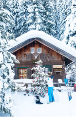 Austria, Altenmarkt-Zauchensee, woman decorating Christmas tree at hut