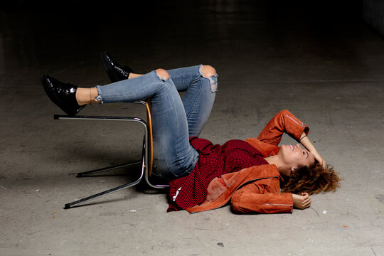 Laughing woman lying on the floor with chair