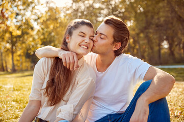 Happy young couple kissing at a park