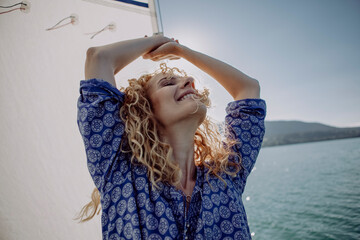 Carefree woman on a sailing boat in backlight