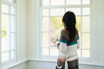 Woman at home looking out of window