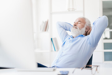 Mature man with beard relaxing at desk