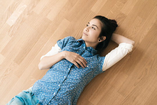 Woman lying on wooden floor