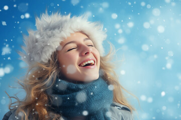 A joyful girl tossing snow into the air against a serene snowy backdrop, with space for text, blue izolated background. 