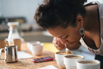 Woman working in a coffee roastery smelling at product