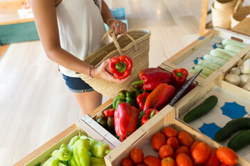 Young woman in organic store choosing vegetables