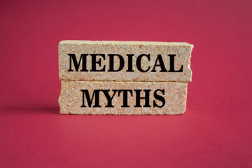 Medicine and health symbol. Concept words Medical Myths on brick blocks. Beautiful red background. Medical and Medical Myths concept. Copy space.
