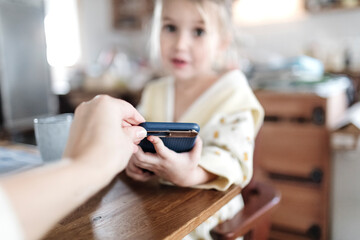 Mother's hand taking away smartphone, close-up