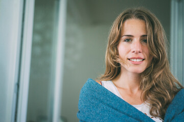 Portrait of smiling young woman wrapped in a blanket - Powered by Adobe