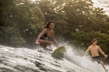 Indonesia, Java, happy woman and man surfing