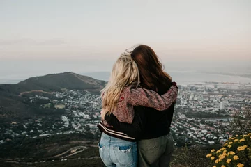 Deurstickers South Africa, Cape Town, Kloof Nek, rear view of two women embracing at sunset © tunedin