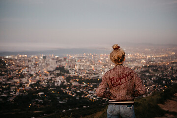 South Africa, Cape Town, Kloof Nek, woman woman looking at cityscape at sunset