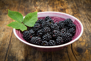 Bowl of organic blackberries on wood