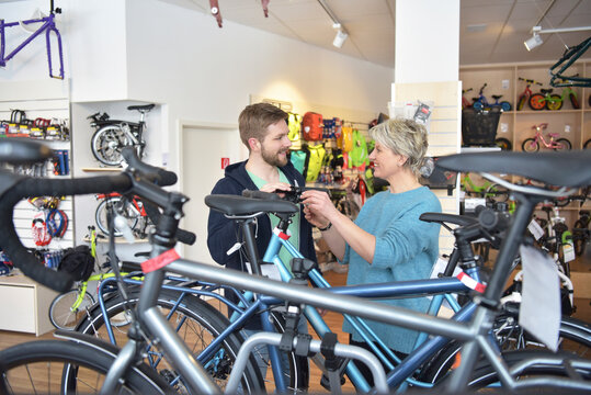 Salesperson helping customer in bicycle shop