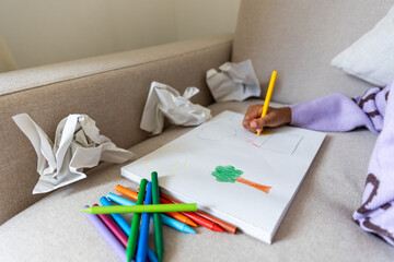 POC child painting a tree with crayons