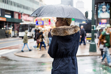Obraz premium USA, New York City, young woman with umbrella on rainy day